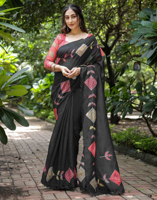 Elegant black printed georgette saree with red ethnic motifs worn by woman”