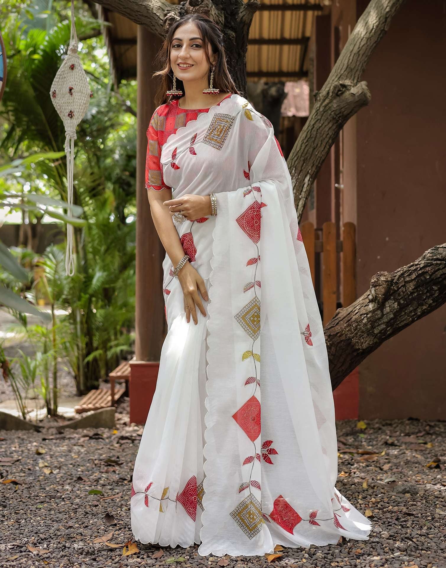 Elegant White printed georgette saree with red ethnic motifs worn by woman”