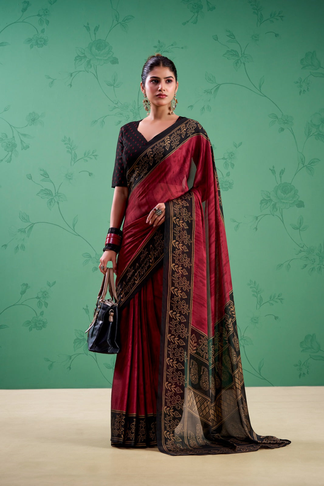 Women’s maroon saree with black and gold traditional border and contrasting blouse